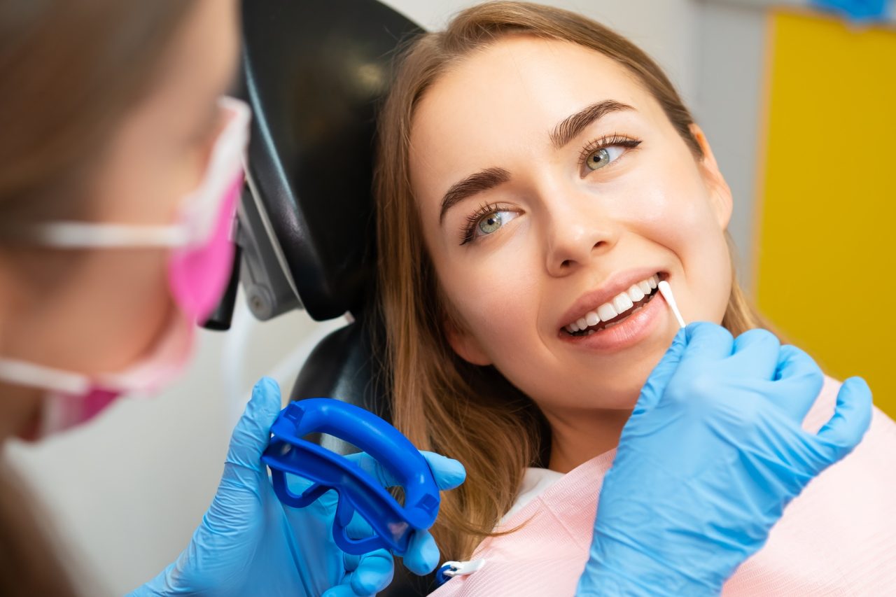 Dentist applies plaque detector on front teeth in clinic.jpg