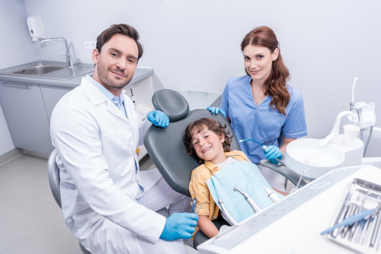 Dentists preparing little boy for examining teeth at dentist office.jpg